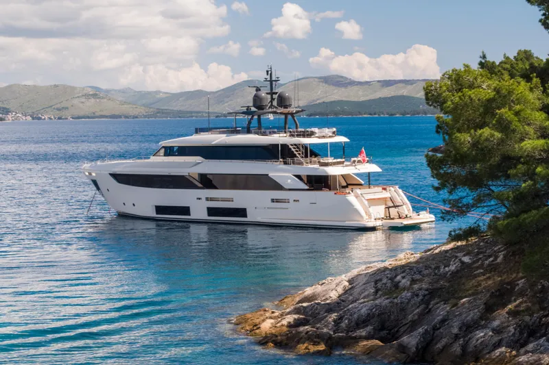 Sk Yacht Photos Pics Luxurious 2019 Custom Line Navetta 33 yacht anchored in scenic coastal waters.