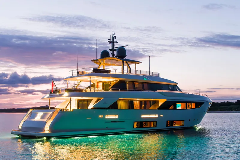 Sk Yacht Photos Pics Luxurious 2019 Custom Line Navetta 33 yacht illuminated at sunset on tranquil waters.