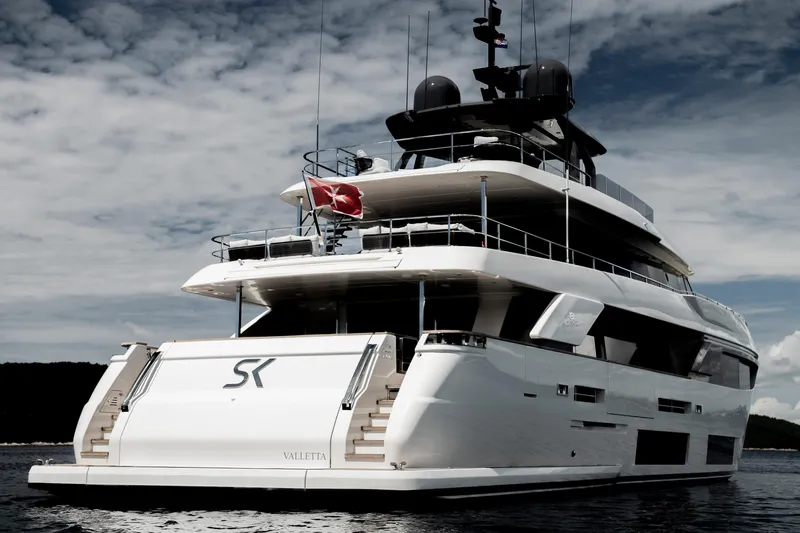 Sk Yacht Photos Pics Luxurious 2019 Custom Line Navetta 33 yacht on serene waters under a cloudy sky.