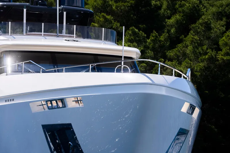 Sk Yacht Photos Pics Luxurious 2019 Custom Line Navetta 33 yacht against lush green forest backdrop.
