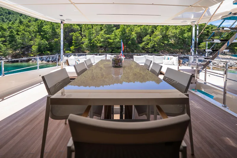 Sk Yacht Photos Pics Luxurious dining area on 2019 Custom Line Navetta 33 yacht, surrounded by scenic greenery.