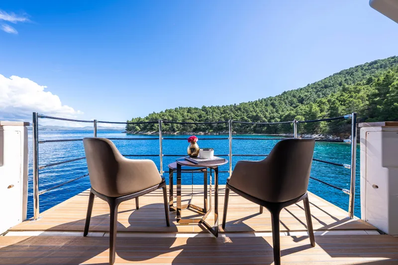 Sk Yacht Photos Pics Luxury yacht deck view with chairs, table, and scenic ocean landscape. Custom Line Navetta 33, 2019.