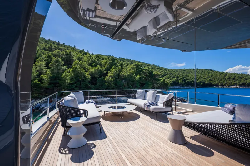 Sk Yacht Photos Pics Luxurious 2019 Custom Line Navetta 33 yacht deck with elegant seating, overlooking serene blue waters.