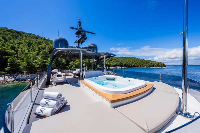 Sk Yacht Photos Pics Luxurious 2019 Custom Line Navetta 33 yacht with jacuzzi, docked near scenic coastline.