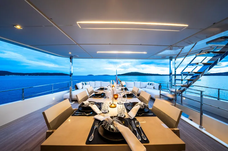 Sk Yacht Photos Pics Luxurious dining setup on 2019 Custom Line Navetta 33 yacht, overlooking serene ocean views.