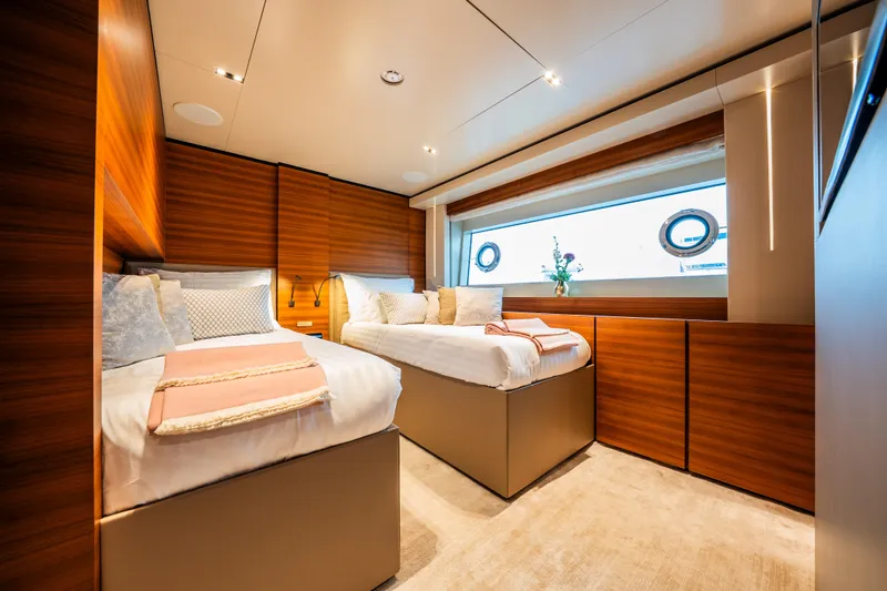 Sk Yacht Photos Pics Luxurious twin bedroom on 2019 Custom Line Navetta 33 yacht, featuring elegant wood paneling.