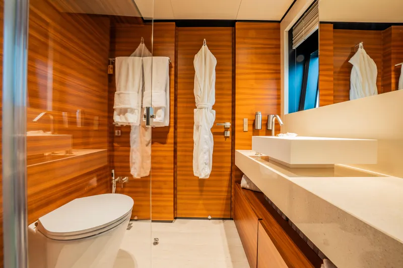 Sk Yacht Photos Pics Luxurious bathroom on 2019 Custom Line Navetta 33 yacht with wood paneling and modern fixtures.