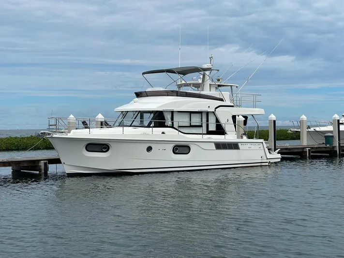  Yacht Photos Pics 2021 Beneteau Swift Trawler 41 Fly docked at marina under cloudy sky.
