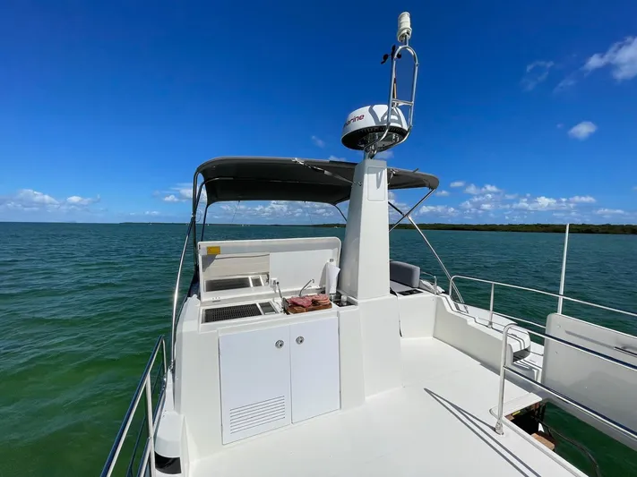  Yacht Photos Pics 2021 Beneteau Swift Trawler 41 Fly on open water, featuring spacious deck and navigation equipment.