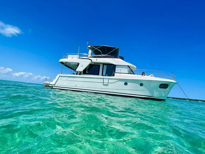  Yacht Photos Pics 2021 Beneteau Swift Trawler 41 Fly on clear turquoise water under blue sky.