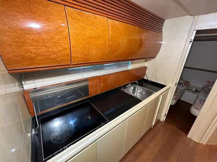 54' Pershing Express Yacht Photos Pics 1999 Pershing 54 yacht kitchen with modern appliances and wooden cabinetry.