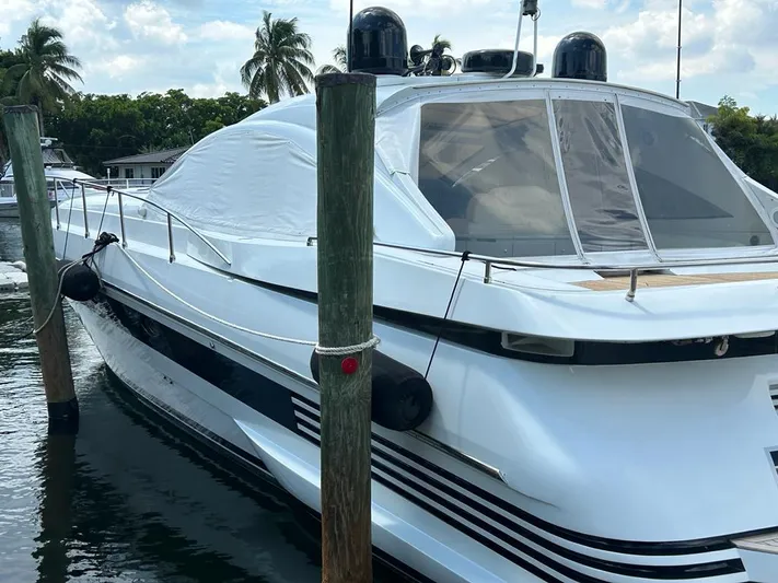 54' Pershing Express Yacht Photos Pics 1999 Pershing 54 yacht docked at marina with palm trees in background.