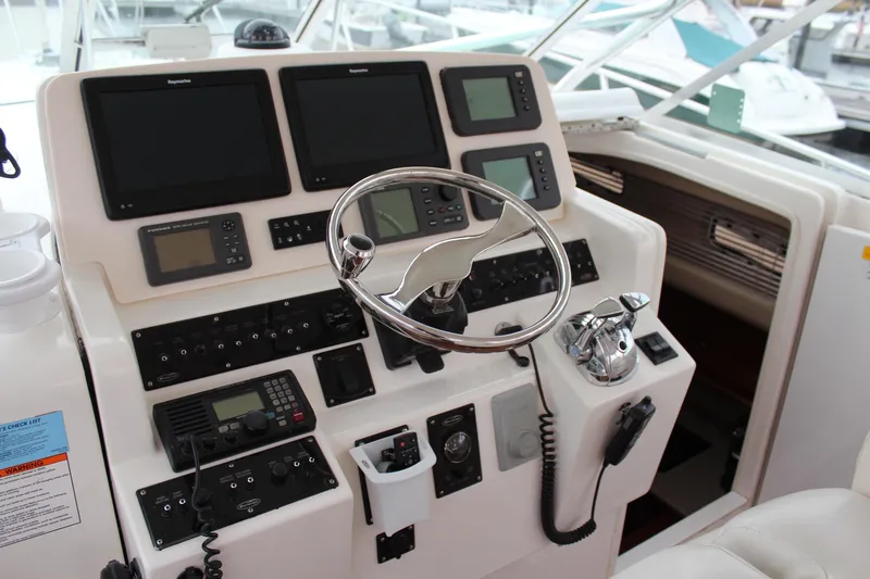 Holly Ann Yacht Photos Pics Control panel of a 2005 Rampage 38 Express boat with steering wheel and navigation equipment.
