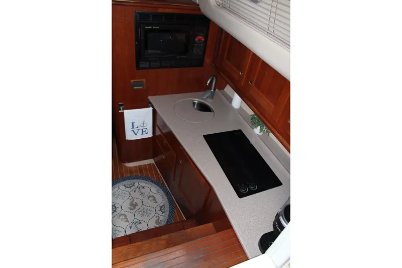 Holly Ann Yacht Photos Pics 2005 Rampage 38 Express yacht kitchen with stove, sink, and wooden cabinetry.
