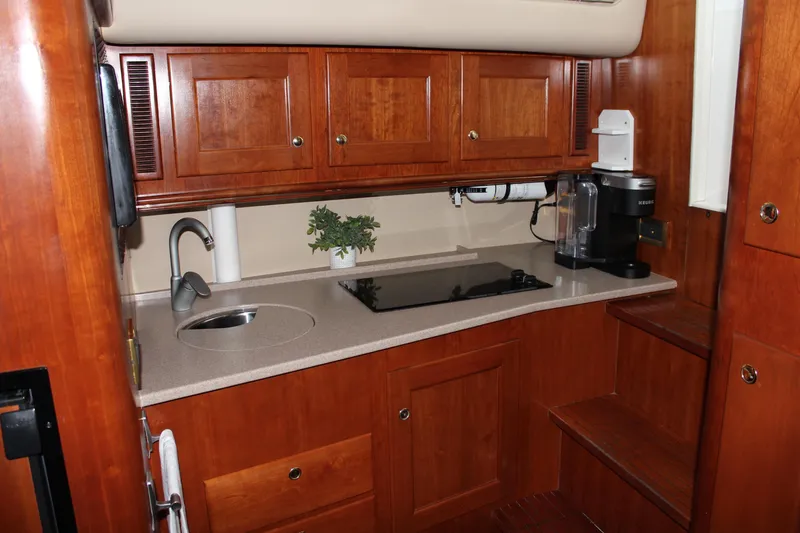 Holly Ann Yacht Photos Pics Luxurious 2005 Rampage 38 Express yacht kitchen with wooden cabinets and modern appliances.