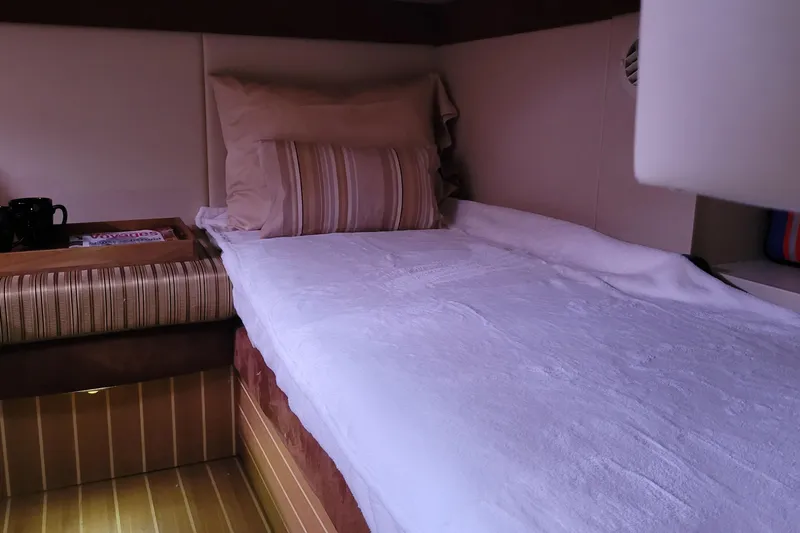  Yacht Photos Pics Cozy cabin interior of 2007 Meridian 341 Sedan yacht with bed and reading materials.