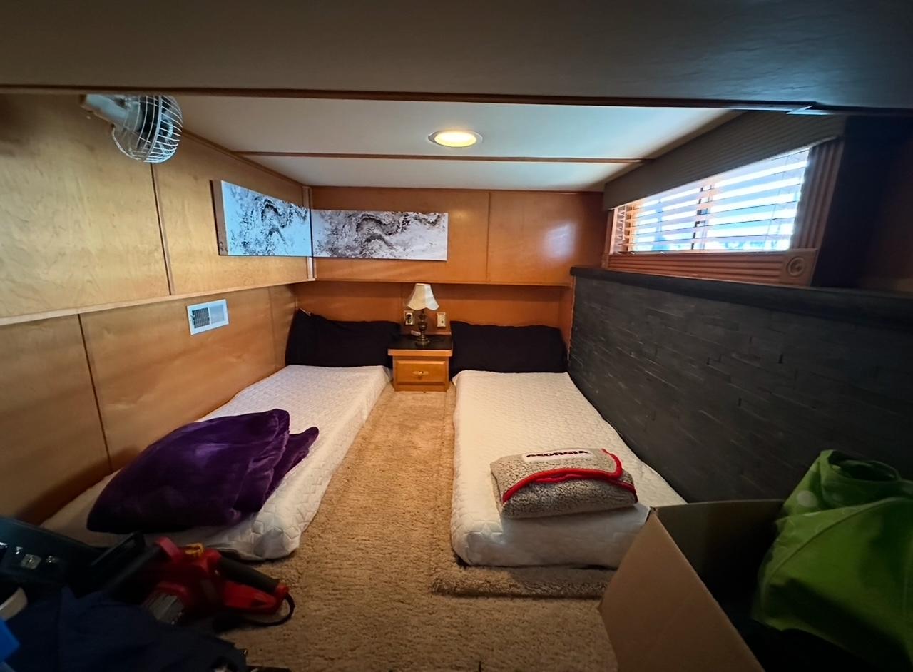 Cozy bedroom in 2006 Lakeview 16x68 houseboat with twin beds and wooden interior.