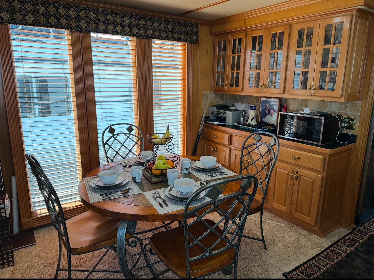 Cozy dining area in a 2006 Lakeview model, featuring a round table and wooden cabinetry.