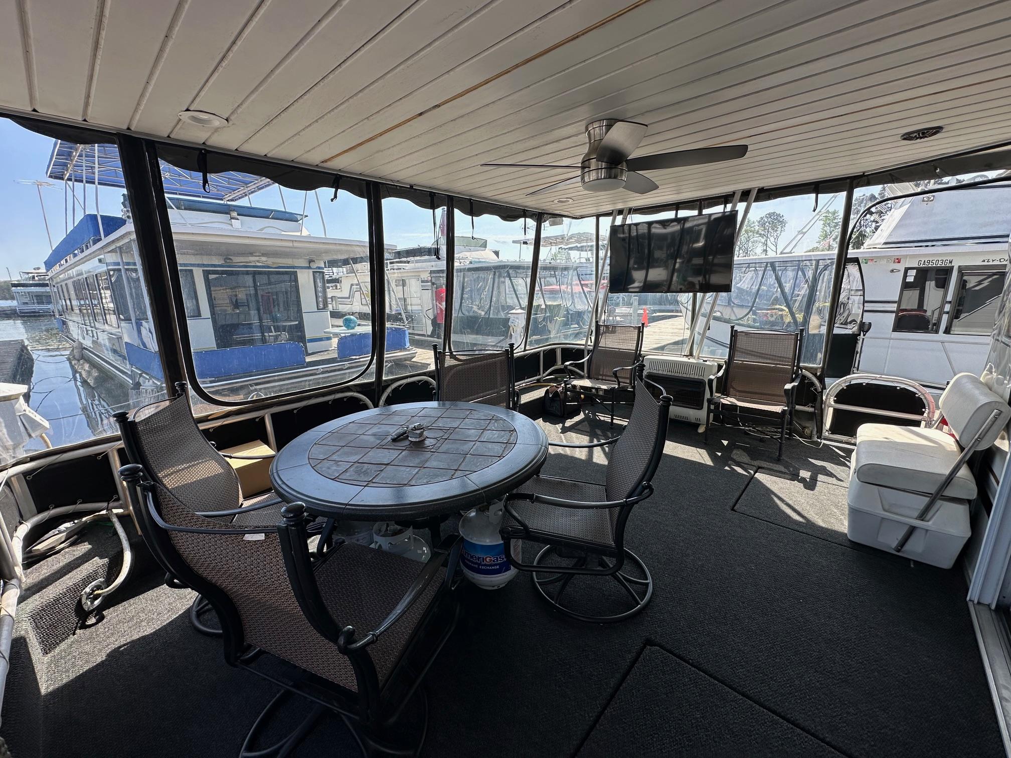 Spacious 2006 Lakeview 16x68 houseboat deck with seating, table, and ceiling fan.