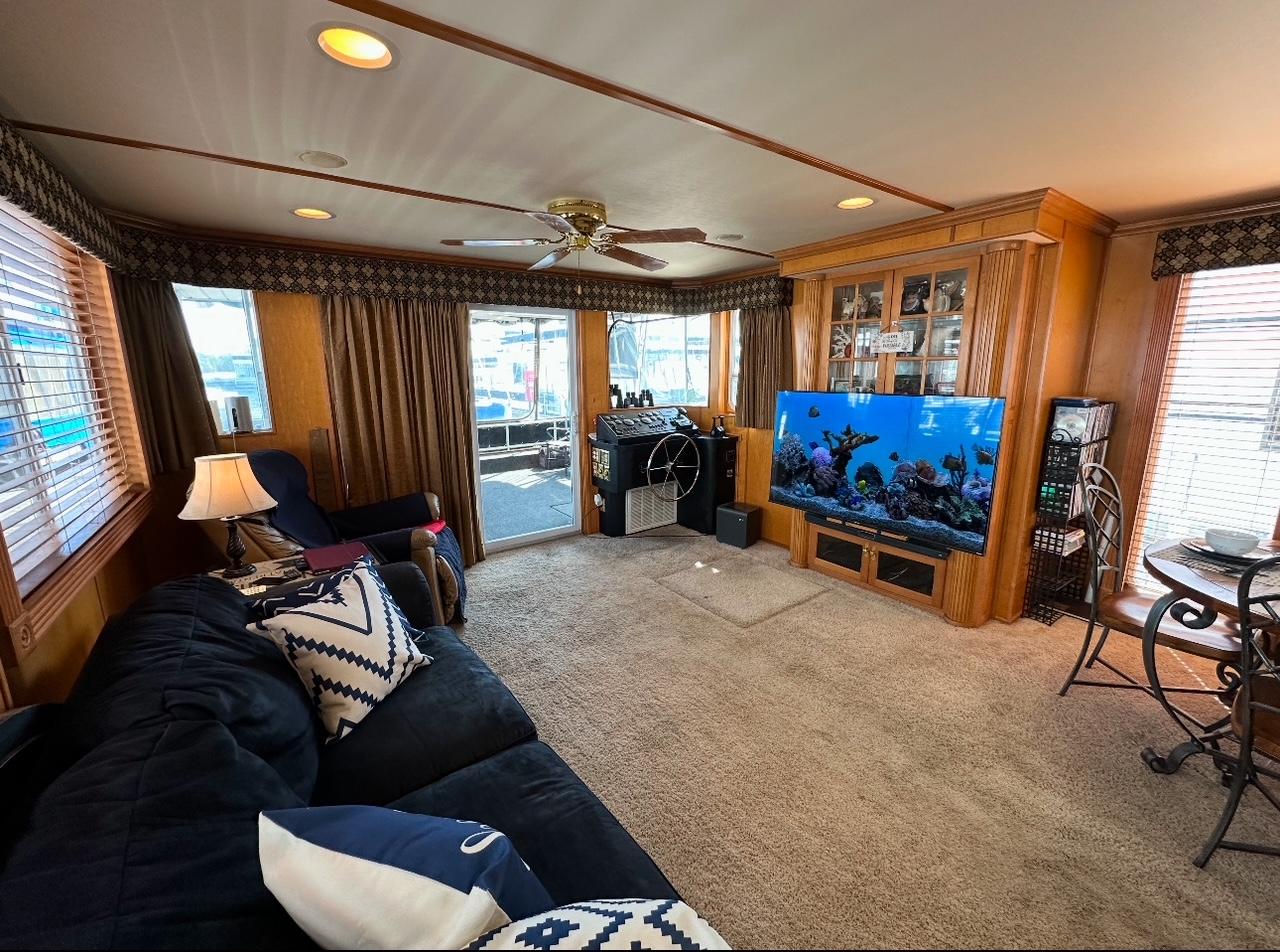 Cozy living area in 2006 Lakeview 16x68 houseboat with large TV and plush seating.