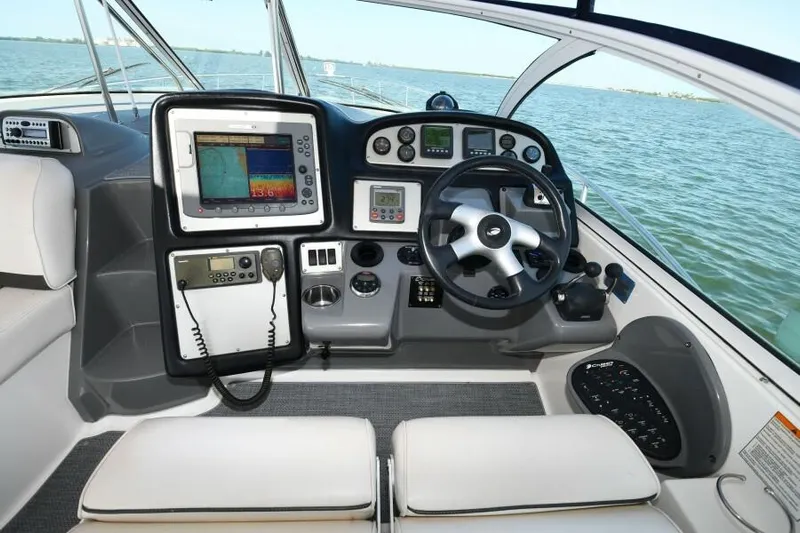 Time 'n Material Yacht Photos Pics 2007 Cruisers Yachts 420 Express helm with navigation equipment and steering wheel, overlooking the water.