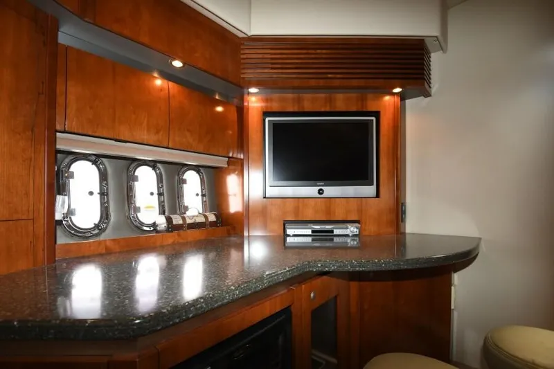 Time 'n Material Yacht Photos Pics Luxurious 2007 Cruisers Yachts 420 Express interior with TV, wood cabinetry, and porthole windows.