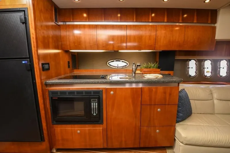Time 'n Material Yacht Photos Pics 2007 Cruisers Yachts 420 Express interior kitchen with wood cabinetry and modern appliances.