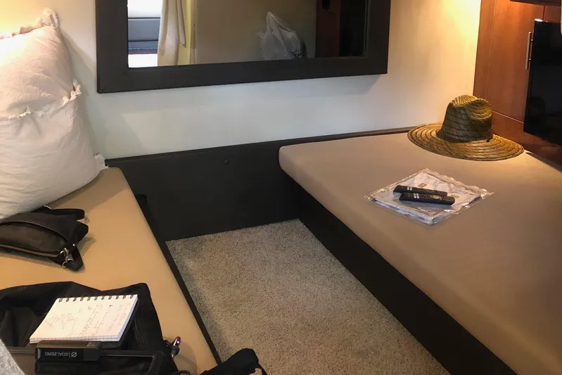 River Time Yacht Photos Pics Interior cabin of 2012 Regal 35 Sport Coupe with seating, hat, and remote control.