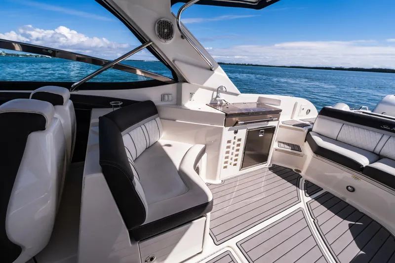 Dock's Knott Inn II Yacht Photos Pics 2018 Sea Ray SLX 350 Outboard interior with seating and kitchenette, overlooking blue water.
