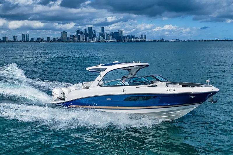 Dock's Knott Inn II Yacht Photos Pics 2018 Sea Ray SLX 350 Outboard cruising on water with city skyline in background.