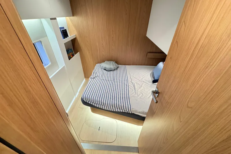  Yacht Photos Pics Cozy cabin interior of 2026 Bali 5.2 yacht with striped bedding and wooden finish.