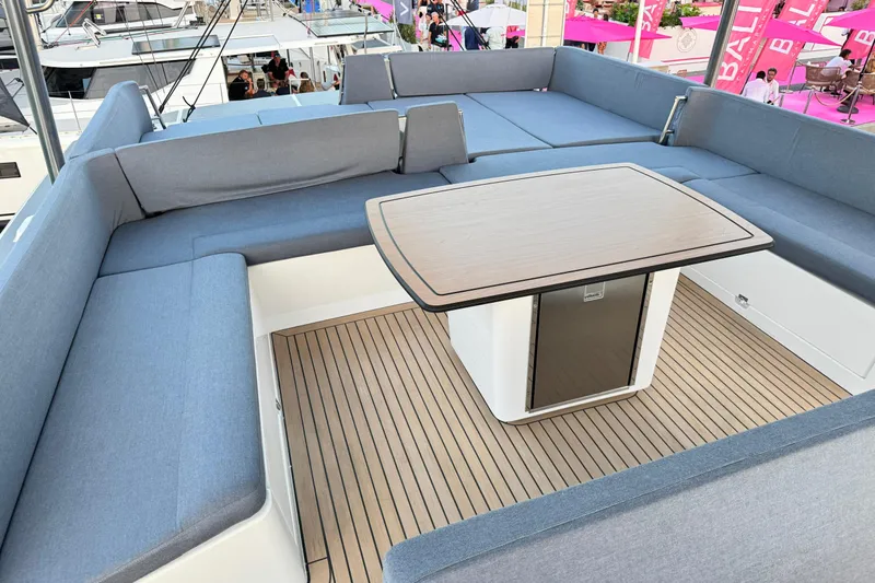  Yacht Photos Pics Luxurious seating area on 2026 Bali 5.2 yacht with wooden table and blue cushions.