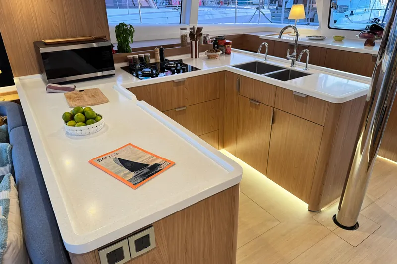  Yacht Photos Pics Modern yacht kitchen interior with wooden cabinets, dual sinks, and countertop decor, Bali 5.2, 2026.