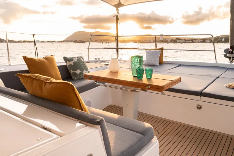  Yacht Photos Pics Luxurious Bali 5.2 yacht deck with cushions, table, and ocean view at sunset, 2026 model.