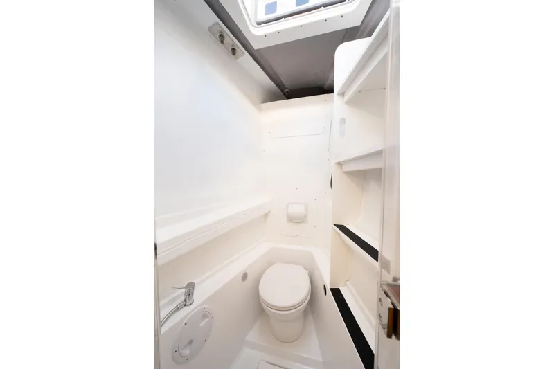  Yacht Photos Pics Compact white bathroom in 2026 Bali 5.2 model yacht, featuring toilet and shelving.