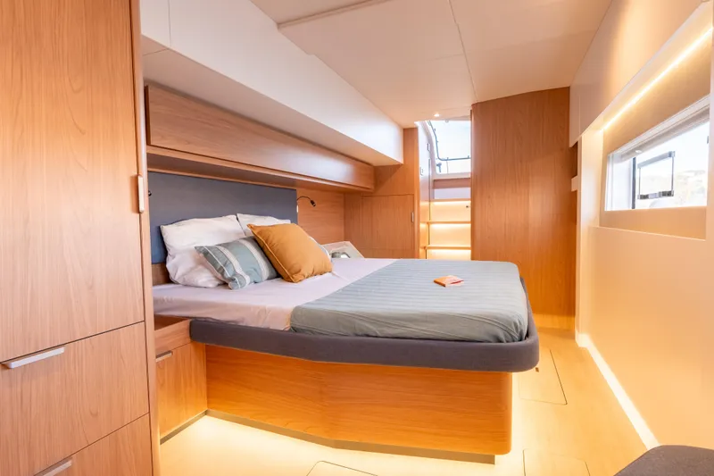  Yacht Photos Pics Luxurious cabin interior of 2026 Bali 5.2 yacht with modern wood finishes and cozy bedding.