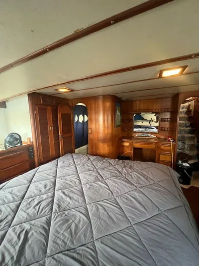 Majestic Yacht Photos Pics 1987 Marine Trader 62 Med Yacht bedroom with wooden interior and large bed.