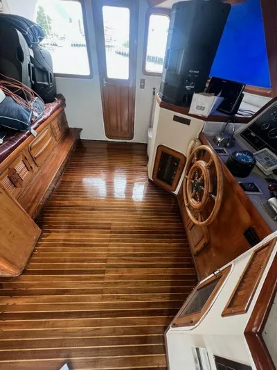 Majestic Yacht Photos Pics 1987 Marine Trader 62 Med Yacht interior with polished wooden flooring and steering wheel.