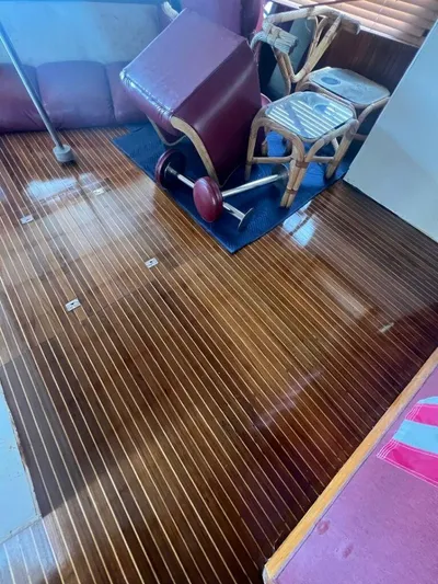 Majestic Yacht Photos Pics 1987 Marine Trader 62 Med Yacht interior with polished wooden floor and overturned furniture.