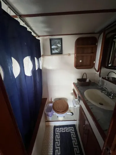 Majestic Yacht Photos Pics 1987 Marine Trader 62 Med Yacht bathroom with sink, toilet, and shower curtain.