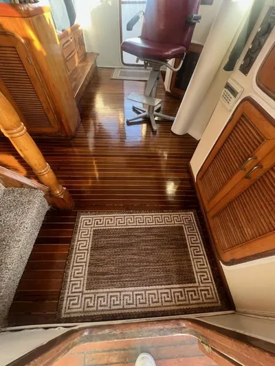 Majestic Yacht Photos Pics 1987 Marine Trader 62 Med Yacht interior with polished wooden floors and a captain's chair.