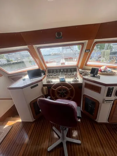 Majestic Yacht Photos Pics 1987 Marine Trader 62 Med Yacht helm station with panoramic windows and wooden steering wheel.