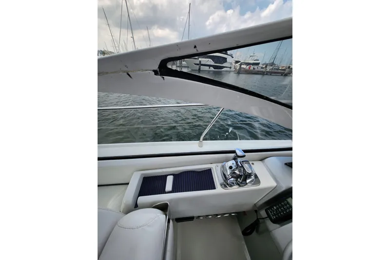  Yacht Photos Pics Interior view of a 2004 Pershing 37 yacht cockpit with marina background.