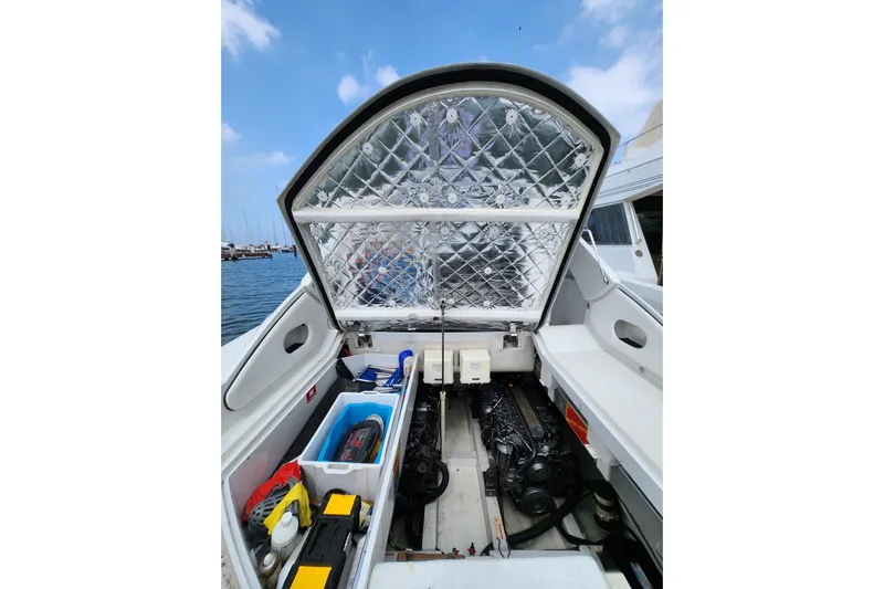  Yacht Photos Pics 2004 Pershing 37 yacht engine compartment with open hatch, docked by the sea.