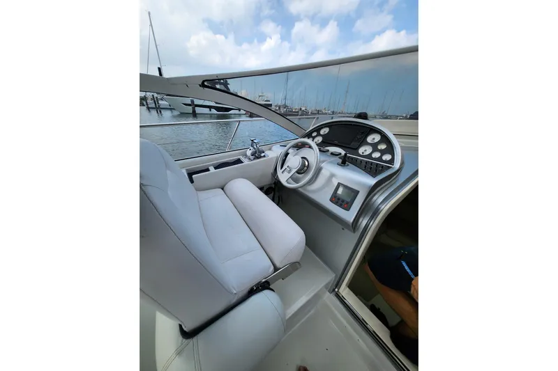  Yacht Photos Pics 2004 Pershing 37 yacht cockpit with steering wheel and control panel, docked at marina.