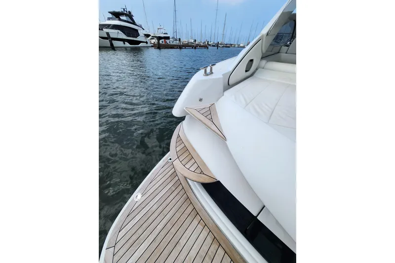  Yacht Photos Pics 2004 Pershing 37 yacht with teak deck, docked in a marina.