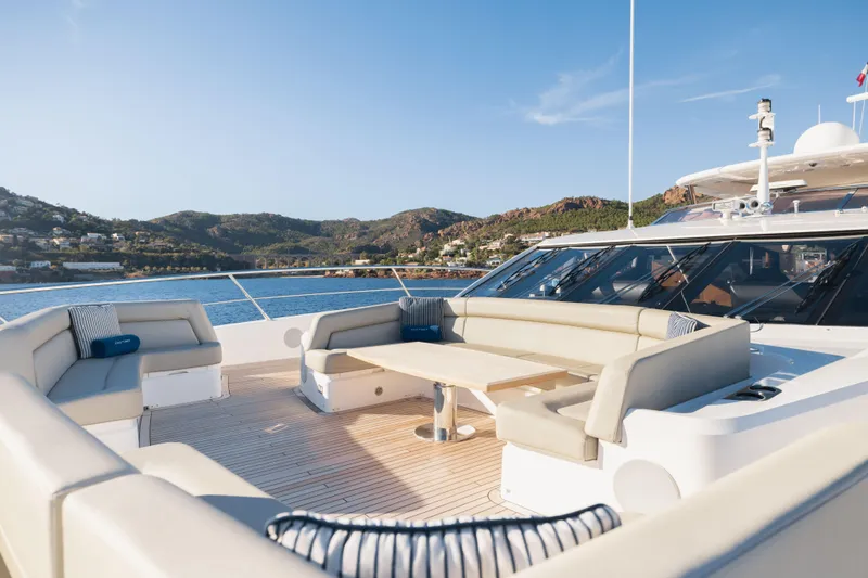 King Power Yacht Photos Pics Luxurious 2016 Sunseeker 116 Yacht deck with elegant seating, scenic coastal backdrop.