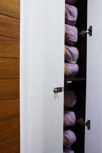  Yacht Photos Pics Open cabinet with neatly stacked purple towels inside.