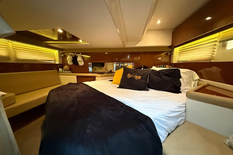  Yacht Photos Pics Luxurious interior cabin of 2014 Sea Ray 370 Venture yacht with cozy bed and ambient lighting.