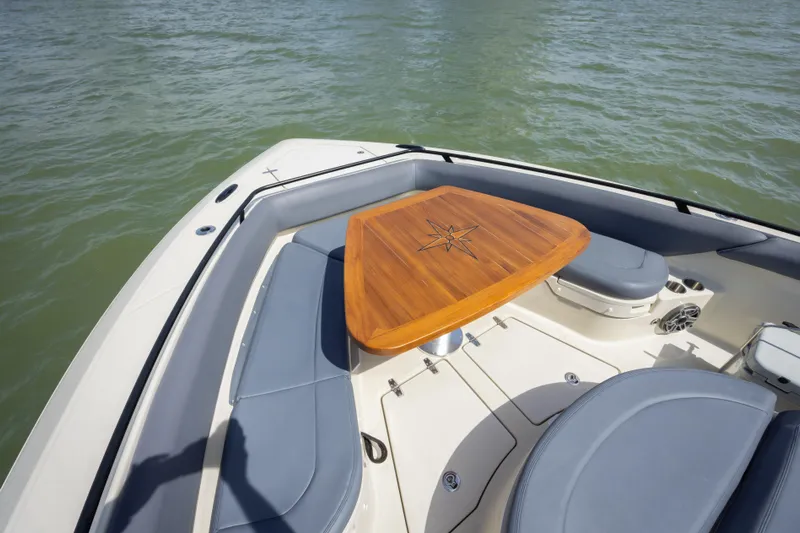 Pachanga Yacht Photos Pics 2021 Boston Whaler 420 Outrage boat interior with wooden table and cushioned seating.